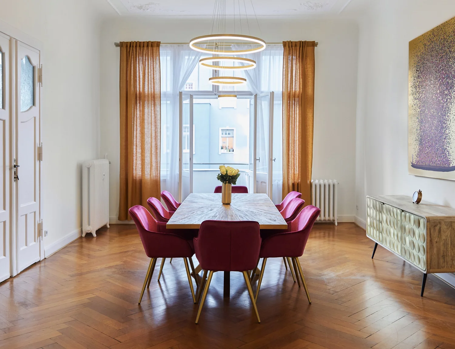 Heller Essbereich mit Designleuchten und roten Stühlen